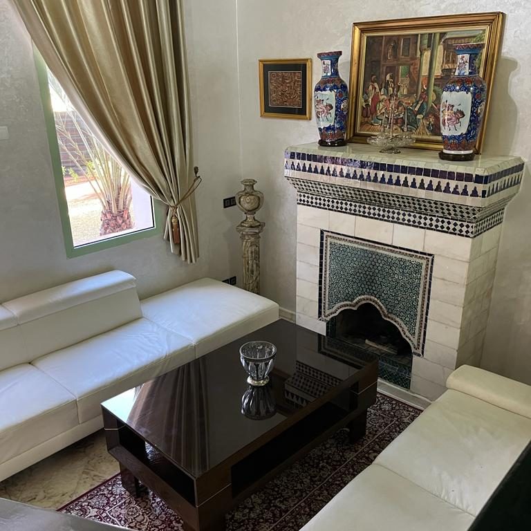 Cozy living room with white sofas, a dark table, and decorative wall elements.