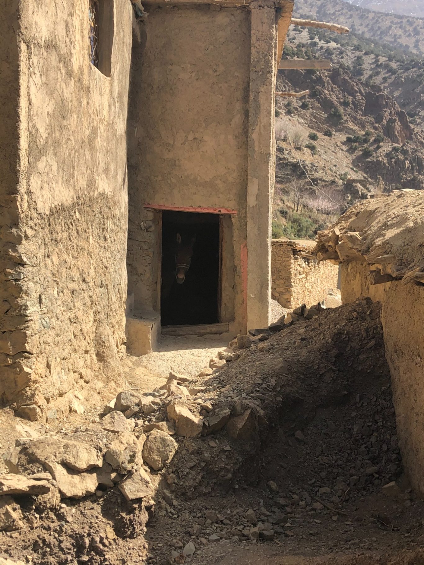 Stone structure with a doorway, set against a rocky landscape.