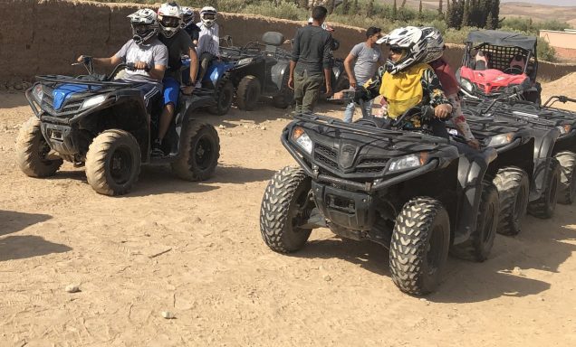 A group of people riding all-terrain vehicles on a dirt pathway.
