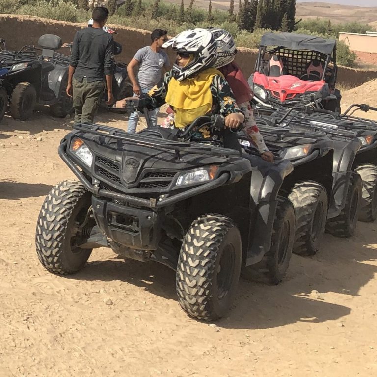 A group of people riding ATVs in a sandy area.