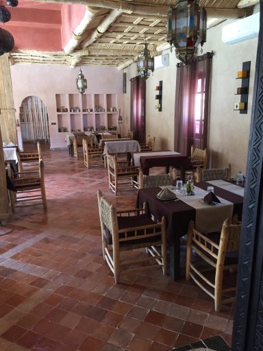 Interior of a rustic dining area with wooden tables and chairs and warm, earthy tones.