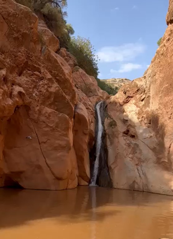 A waterfall cascading down rocky cliffs into a tranquil pool.