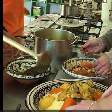 Hands serving food from a pot into traditional bowls, featuring carrots and other ingredients.