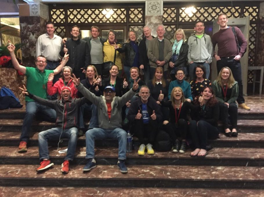 A group of diverse people posing cheerfully on a staircase.