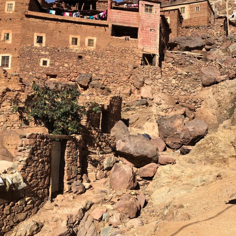 Rocky landscape with traditional mud-brick houses nestled against a hillside.