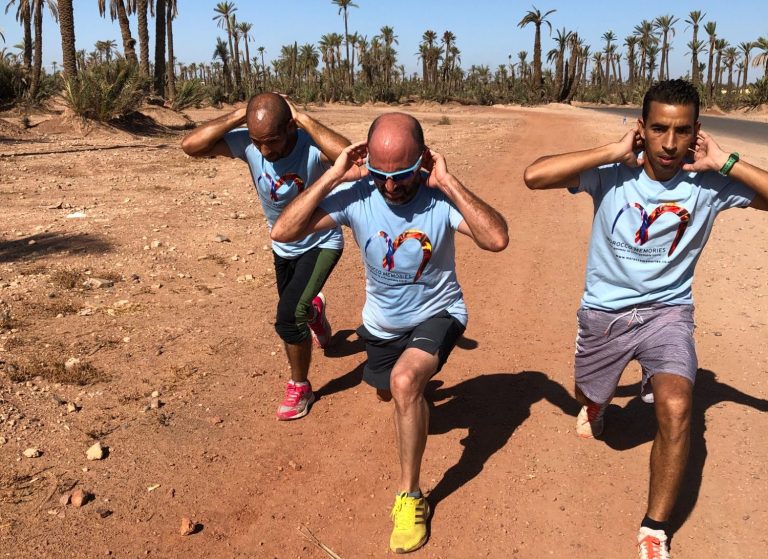 Three people in fitness attire performing lunges on a dusty desert path.