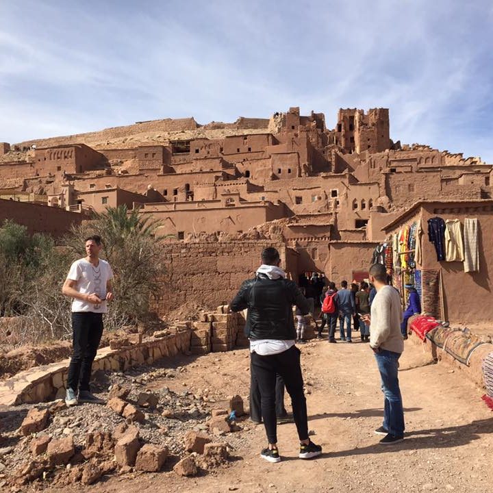 People exploring the ancient clay architecture of Aït Benhaddou in Morocco.