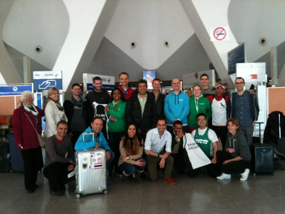 Group of people gathered at an airport, smiling and posing for a photo.