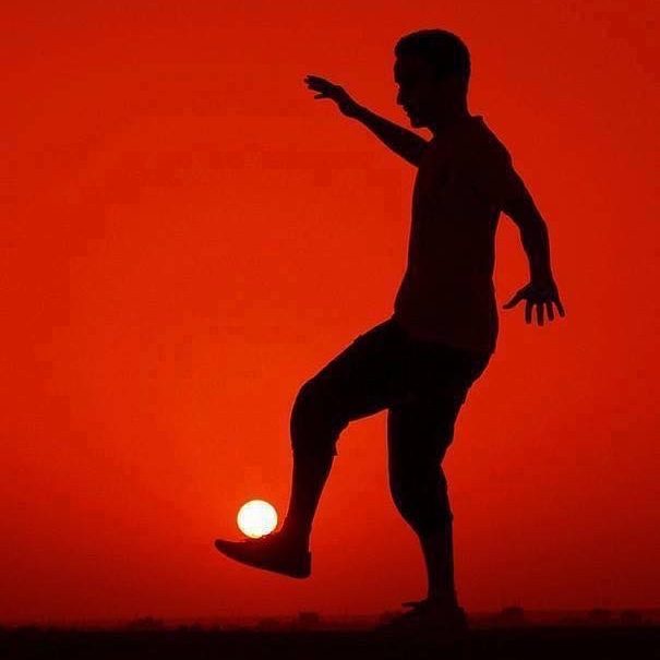 Person wearing traditional attire holds two plates of fresh salad in a tiled setting.