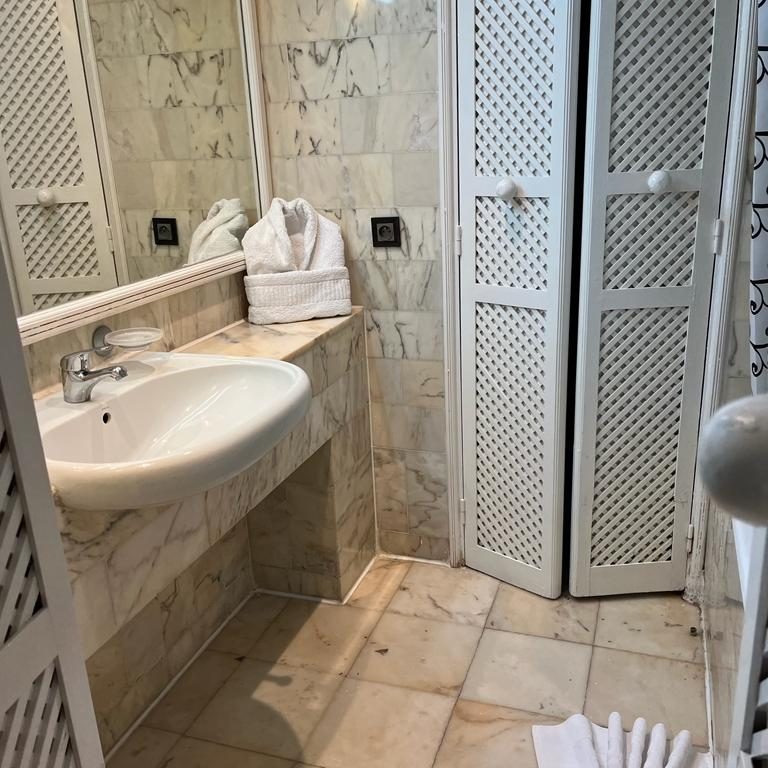 A clean bathroom with a sink, mirror, towels, and a cabinet.
